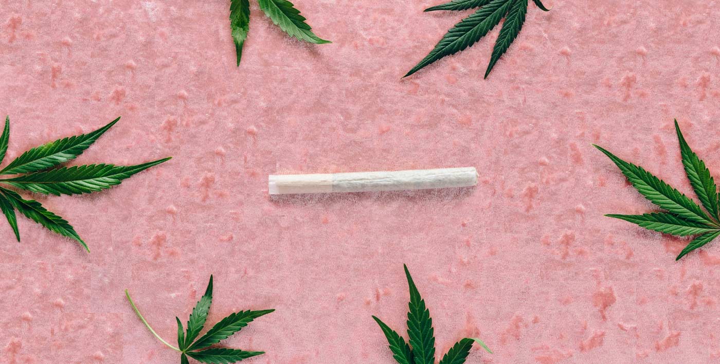 cbd preroll on pink fabric with weed leaf 